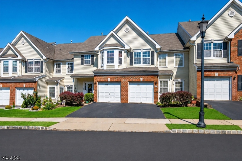 Welcome to the Traditions community where a soaring two-story living room, unbeatable commuter location and property backing up to wooded tree line checks all the boxes. This Heritage B model has both a living room and a family room. The inviting floor plan features a sun-filled living room, formal dining room and an eat in kitchen that opens to a family room with a gas fireplace. The kitchen is upgraded with granite countertops, crown-molded cabinetry, and newer stainless steel appliances. Upstairs, the spacious primary suite boasts a vaulted ceiling, walk-in closet, and private bath with a soaking tub and separate shower along with another bedroom, full bath, and convenient second-floor laundry complete the upper level. The full spacious basement features high ceilings and fresh paint, offering abundant storage and outstanding potential for future finished living space. Additional highlights include an attached garage, private driveway,and updated mechanicals including the furnace, central air and hot water heater. Residents enjoy exceptional amenities including a clubhouse, fitness center, outdoor pool, and playground. Ideally located just minutes from the Metuchen station and Edison station, Rutgers University, Route 287, shopping, dining, and everyday conveniences. Enjoy the ease of low-maintenance living in a location that truly has it all.