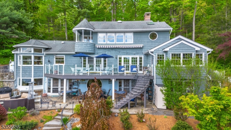 Welcome to your perfect lakeside retreat! This magnificent lakefront home offers an unparalleled blend of luxury, comfort and outdoor living. Nestled on an expansive 300' lake frontage lot, this property is a true paradise for boating, fishing, or relaxing by your stunning heated in ground pool complete with a breathtaking waterfall and custom firepit. Throughout this home, you will see the finest of details. Three levels of living space provide 4 spacious bedrooms, 3.1 baths and 2 kitchens. The gorgeous primary suite offers an updated stunning master bath, two walk in closets and its own balcony with the most amazing views! The secondary oversized entertainer's kitchen with commercial grade appliances will satisfy your "inner chef" over and over.  The home is decorated with walls of the most spectacular windows and breathtaking views. The recently installed composite decking with custom curved railing is sure to satisfy the most discerned buyer. This property is professionally landscaped with many specimen plants, gorgeous perennials & complete with a lawn irrigation system. Additionally you will find custom lighting, a luxurious retractable awning and two docks for your lake life needs.  Pride of ownership is abundant. Come see this stunning, rare opportunity home.