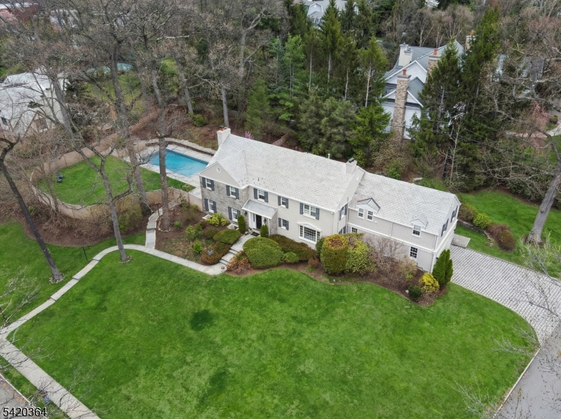 A HOME WHERE YOUR STORY THRIVES! Set on an idyllic street adjacent to Yantacaw Brook Park, this beautifully renovated gem offers a rare blend of elegance, comfort & effortless indoor-outdoor living. Stunning, fully reimagined kitchen - open, inviting, & designed for everyday life & entertaining. White marble countertops & a center island that will be the center of everything from pancakes to homework!  Adjacent family room w/gas fireplace offers a seamless flow of life & light. Inviting dining room with views of patio & gardens. Fabulous living room with windows on 3 sides, built-ins, gas fireplace & french doors to patio & pool. Stately curved staircase up to Primary Ensuite with dressing room & full bath, 4 additional bedrooms, bonus room, 2 full baths & laundry room. Fully renovated lower level is a true standout - bright & thoughtfully finished with raised flooring, wool carpeting, built-in sound, climate control, & multiple windows - a stellar space for play, fitness & gathering year-round. Outside, the vibe is private retreat. A saltwater pool with gorgeous bluestone surround & retractable cover anchors a section of the backyard with plenty of fully-fenced play space beyond.  Lush grounds, fish pond & waterfal. Belgian block driveway and slate roof add timeless appeal.  New multi-zone HVAC. Extensive updates throughout.  Space, style, and ease - just moments from parks, schools, and NYC access. More details in photo captions.