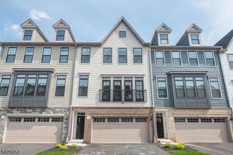 Welcome to The Grove at Upper Saddle River. This Briercliff model features extensive builder upgrades and backs to a private wooded setting. The open concept floor plan provides excellent natural lighting and is designed for both everyday living and entertaining, featuring a main-level office and a dining area with sliders to a deck. The kitchen offers a large center island, upgraded cabinetry, and full roll-out shelving for added convenience. Upstairs, the primary suite features a finished walk-in closet and a spa-like bath with a rain shower. Two additional bedrooms feature finished closets, and the hall bath includes a double sink vanity. A laundry room with added cabinetry completes the upper level. The finished lower level provides flexible living space with a recreation room that walks out to a paver patio, along with built-in shelving and space for a mini fridge. Upgrades throughout include custom hardwood flooring, iron rod railings, a stone fireplace, Sonos sound system, custom blinds, enhanced pantry shelving, and built-in garage storage. Excellent location - minutes from two train stations, bus stops, major highways, restaurants, shopping and entertainment. A perfect blend of style, function, and privacy move right in and enjoy.