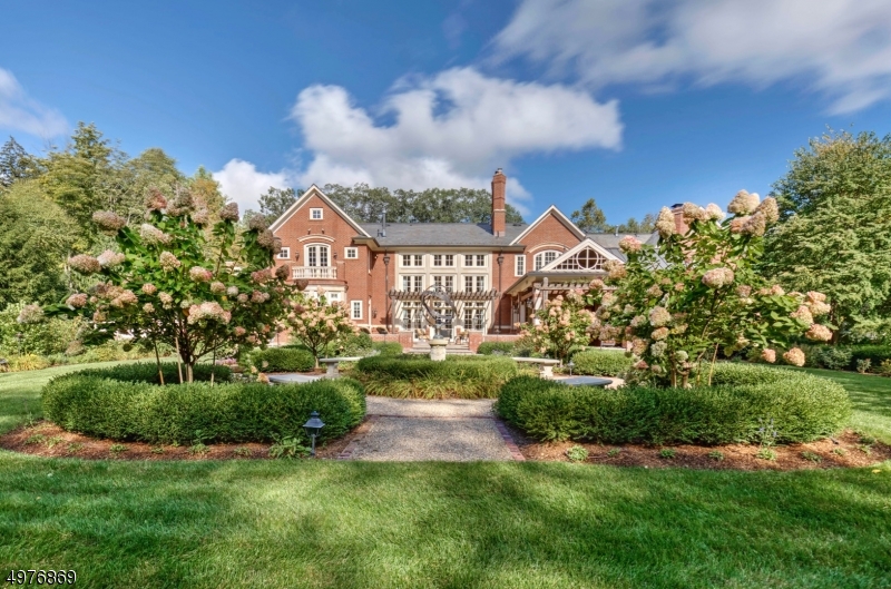 Just 45 miles from NYC, Hop on a train and/or route 287 or 78 from this beautiful home.  The extensive attention to detail include a Vermont slate roof & outdoor living space(covered & open) provide a private oasis to enjoy. The blue stone patio encompasses wood burning fp, tv, full kitchen, koi pond & gracious gardens each lending a hand to easy entertaining.  The grand 2 story foyer and spacious rooms offer opulent living throughout. Notable features include: cherry wood paneled library, 2 story fam room with floor to ceiling custom millwork and 3 sets of french doors to patio, 2 oversized islands in custom eat in chef's kitchen, butler's pantry, large liv and din rooms, spectacular theater rm, 4+ fireplaces, 2nd floor master bedroom balcony, and exercise room are just some highlights.