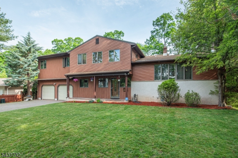 Welcome to this expanded split-level in highly desirable Packanack Manor, with nearly 3,000 square feet of living space, offering an exceptional blend of space, functionality, and updates throughout. This impressive home features 4 bedrooms, 4 full baths, and 1 half bath, including a private junior suite with its own renovated full bathroom and a luxurious primary suite complete with a walk-in closet and oversized bath featuring a renovated stall shower, jetted tub, water closet with bidet, and room to install laundry. Enter into a spacious tiled foyer with coat closet and renovated powder room, while a nearby office offers flexibility as a potential 5th bedroom. The renovated kitchen features custom cabinetry, granite countertops, double wall ovens, and a center island with gas cooktop, attached table seating, and breakfast bar that opens directly to the family room. Beyond the family room is access to the oversized 2-car garage and a finished pool/hot tub room with a full bath and sliders leading to your covered outdoor hot tub retreat. The dining room opens into the great room with a wall of windows overlooking the expansive deck and above-ground pool, while a few steps up is a spacious living room with fireplace. A finished basement with laundry, full paver driveway, and underground sprinkler system complete this exceptional home.