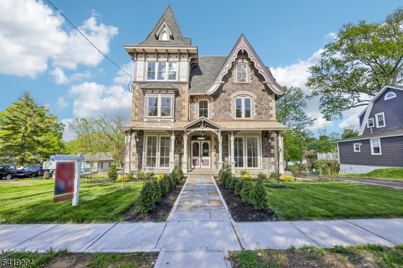Stunning Puddingstone Victorian blending modern luxury and old-world charm. Beautifully restored top to bottom: new flooring, mechanicals, central air, custom built-ins, and high-end finishes throughout. Iconic details include carved woodwork, custom arched front doors, copper accents, and purple-hued puddingstone that sparkles in the sun. A rare chance to own historic architecture with every modern comfort while near shops, restaurants, parks, and NJ Transit. Currently a two-family home. Unit #1 (ground + lower level): 3 BR, 2 BA with historical character flowing into an open-concept kitchen with center island and dining/living space. First-floor bedroom features a decorative fireplace and oversized floor-to-ceiling windows. Lower level walks out to a covered patio, backyard, and private parking with two EV charging stations. Unit #2 (2nd + 3rd level): 4 BR, 3 BA with exquisite finishes and thoughtful design. Stylish kitchen with high-end appliances and ample storage. Show-stopping primary suite boasts 20' cathedral ceilings, exposed wood beams, a dressing area, walk-in closet, and stunning en suite. Curb appeal is an understatement for this property with fresh new landscaping, private parking with charging stations, rear deck and a spacious backyard area!  Prime location allows you to embrace the best of suburban living with direct access to Main Street in Madison, fun neighboring towns, and a just quick trip to NYC!