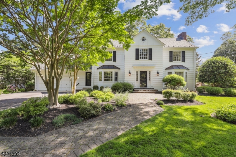 Beautifully located in the prestigious Hill section of Madison perfectly set behind the stone wall, this stately updated classic white Colonial with 6 bedrooms and 3.2 baths is full of sunlight, enjoys gleaming hardwood floors, architectural interest throughout and is just blocks to town, train and schools. This spacious home features a generous foyer, large living room with fireplace, formal dining room, family room, first floor office, eat in kitchen with breakfast bar, wolf cooktop, Subzero fridge and two Fisher Paykel dishwashers. Continue to the second level that boasts 6 bedrooms and three updated full baths, and a back staircase.  The primary suite offers a large bedroom, very spacious closet, ensuite bath with 2 sinks and a shower and a lovely sitting room over looking the beautiful yard.  The basement is partially finished with plenty of storage. Outside is beautifully landscaped with mature trees, shrubs and perennials and an expansive flat private yard perfect for play, gardening and relaxing.  An oversized blue stone patio and deck allows you to enjoy the outdoors and is perfect for entertaining outside.  Many updates include a newer roof, furnaces, A/C, hot water heater, renovation of all the full baths and more!  Enjoy all Madison has to offer voted #1 place to live by NJ Monthly in this amazing home!