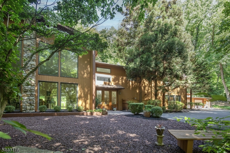 This Dramatic contemporary style home sits majestically on 5 very private wooded acres.  For those desiring a sanctuary surrounded by gardens, waterfalls and groomed walking trails.  Soaring walls of windows invite the outside in!  Grand two story entry leads to an open floor plan for living and dining areas.  The kitchen features professional grade appliances and is the heart of the home. A cozy library/family room features built ins and ceiling to floor windows.  The primary suite offers walk in closet and full bath.  There are two generous sized bedrooms also on the second floor. A loft serves as an office which overlooks the spacious open first floor. An expansive deck reaches across the back of the home and leads to the waterfall pond, walking trails and beautiful gardens.  An oversized two car garage provides for huge storage area . An extraordinary offering in a great location with easy access to Rts 31 and 78 and major recreational areas.  A very special property!