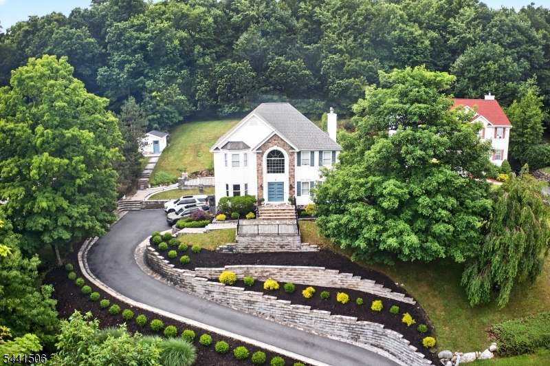 Welcome to this exceptional center hall colonial in Byram's sought-after Autumn Hill neighborhood, where timeless design, quality craftsmanship, and luxurious living come together beautifully. Sparta mailing address. From the moment you arrive, you'll appreciate the professionally designed landscaping, gorgeous stonework, and extensive hardscaping that create outstanding curb appeal and a memorable first impression. Inside, this home feels straight from the pages of a magazine. Gleaming hardwood floors, elegant accent walls, and thoughtfully selected finishes create a sophisticated yet welcoming atmosphere. The spacious floor plan is ideal for both everyday living and entertaining. The luxurious primary suite offers a spa-inspired bathroom and generous walk-in closet. The fourth bedroom is currently being used as a custom dressing room and boutique-style closet, complete with a center island, extensive storage, and a dramatic shoe wall. This versatile space can easily be converted back to a bedroom if desired. Storage is plentiful throughout the home. Step outside to your own private backyard retreat featuring an expansive deck, inviting pergola, and relaxing hot tub the perfect setting for entertaining, summer gatherings, or quiet evenings at home. A storage shed provides additional space for outdoor equipment and seasonal items. Located in desirable Autumn Hill, this remarkable home offers the perfect blend of elegance, comfort, and attention to detail.