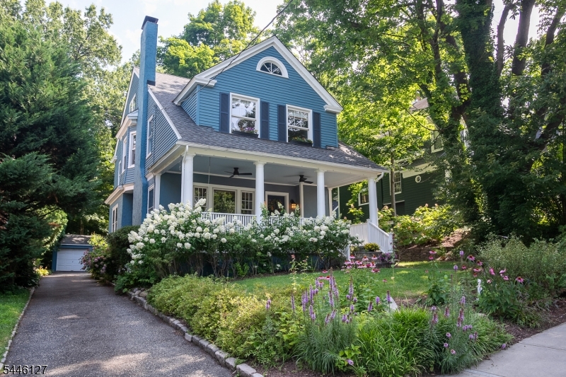 Ideally-located and picture-perfect 5BR, 3.5BATH Colonial just one block to the direct train to NYC and steps to Maplewood Village, restaurants, cafes, shops, Memorial Park, library, schools & playground! A welcoming front porch w/ceiling fans is the perfect place to relax & greet neighbors. This well-maintained, charming home offers 4 lvls of living space filled w/thoughtful updates. The 1st flr features a spacious Living Room w/original woodwork, working wood-burning FP & cozy window seat, elegant Dining Room w/bonus room & renovated Kitchen w/quartz counters, lots of storage & newer stainless steel appliances. This plus a mudroom & back door access to the deck.  The 2nd flr offers 4 generous bdrms, plus 2 updated full baths. The primary suite features ample storage & ensuite bath. The 3rd flr adds a 5th bdrm/home office plus a full bath w/classic clawfoot tub & lots of storage space. The newly-finished lower level includes a rec room, exercise area, 1/2 bath, workspace, laundry & has French drains & sump pumps. Professionally landscaped grounds feature a spacious deck, patio, stone walls, flowering perennials & wooded back enclave for exceptional privacy. Amenities include newer 2-zone central AC, whole-house generator, new water purification & softening systems, sprinkler system, new hot water heater & newer appliances. A rare opportunity to own one of Maplewood's sweetest homes in the most desirable location- do not miss this one!