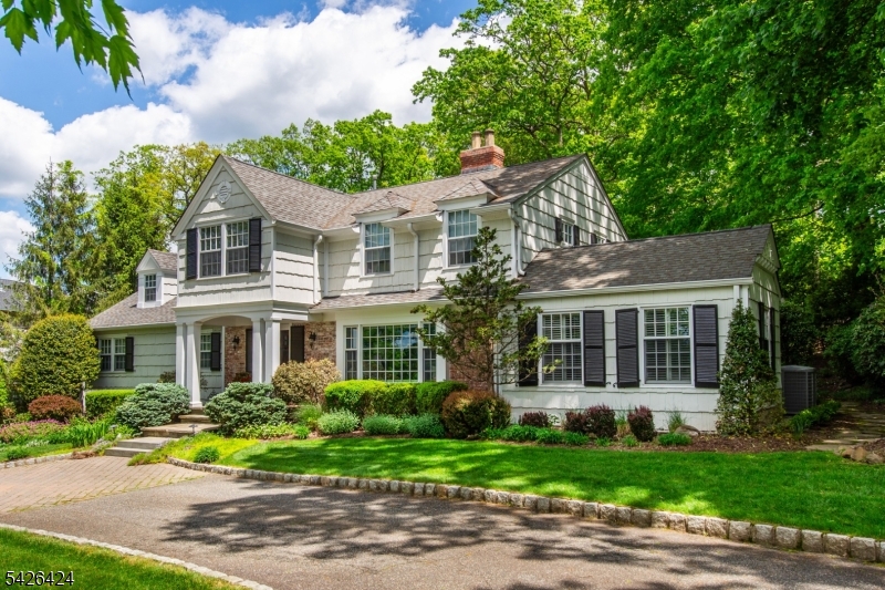 Nestled within the prestigious Deerfield section of Short Hills, this distinguished residence offers a rare opportunity to own a home defined by timeless elegance, expansive living spaces, and exceptional privacy. Set on beautifully landscaped grounds with a serene wooded backdrop, the property enjoys a peaceful, almost estate-like setting rarely found in such a coveted neighborhood.Classic architecture and meticulous landscaping frame the home with quiet sophistication, creating an inviting sense of arrival. Inside, graciously scaled rooms unfold with an effortless flow, offering both elegant spaces for entertaining and comfortable areas for everyday living. Expansive windows invite natural light to pour in while capturing tranquil views of the surrounding greenery. The home's generous proportions allow for both intimate gatherings and larger celebrations. A private ground-level suite provides ideal accommodations enhancing the home's flexibility.Outdoors, the beautifully landscaped property creates an exceptional setting for outdoor living, featuring a lovely patio with an outdoor kitchen, intimate seating areas, and a sweeping level lawn. The wooded landscape beyond enhances the sense of privacy and tranquility.All of this while enjoying the convenience of being within walking distance of highly regarded Deerfield Elementary School.