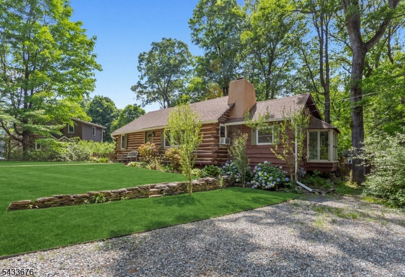 A rare blend of rustic charm and timeless character in the heart of sought-after Fayson Lakes. Welcome to 6 Partridge Trail, an expanded 3-bedroom, 2-bath log cabin home set on a large, flat lot in one of Kinnelon's most desirable lake communities. This unique home showcases authentic log construction paired with warm wood finishes, creating a cozy yet spacious retreat. Step inside to a stunning open-concept living area with soaring vaulted ceilings, exposed beams, and a dramatic stone fireplace, the true centerpiece of the home. Natural light pours in through oversized windows, while the adjoining dining area features a charming bay window overlooking the property. The kitchen offers rustic cabinetry and a functional layout ready for your personal touch.A standout feature is the classic Fayson Lakes sleeping loft, accessed by a spiral staircase. Perfect as a guest space, home office, or creative retreat.Outside, enjoy a spacious deck ideal for entertaining and a peaceful backyard surrounded by natural beauty. Located in the coveted Fayson Lakes community, residents enjoy access to lakes, beaches, and a true neighborhood lifestyle.A rare opportunity to own a character-filled home in a prime location!