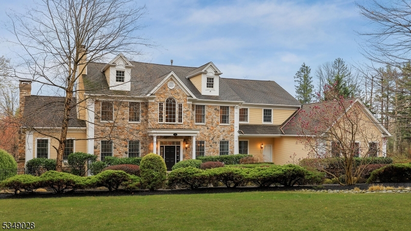 Nestled on a quiet street, this center hall custom Colonial offers refined living with designer touches throughout. A professionally landscaped private yard provides breathtaking vista views and an elevated sense of privacy. The grand foyer with soaring cathedral ceilings introduces the home's elegant scale. The entertaining room exudes warmth with rich moldings, textured walls, beamed ceilings, an oversized stone fireplace, and a granite and wood bar. Hardwood floors flow through to the family room, where reclaimed barn wood walls, a stacked stone feature, and a coffered ceiling create inviting ambiance. A double-sided butler's pantry offers seamless entertaining. The sunlit kitchen is anchored by a granite island and a full wall of windows overlooking the yard and resort-style pool. French doors lead to a large deck and pool area below. The luxurious primary suite features a sitting room, spa-like bath, and two oversized walk-in closets. All bedrooms are ensuite. The walkout basement offers a media room, rec room, wet bar, full bath, workshop, and guest bedroom blending luxury and comfort at every level.