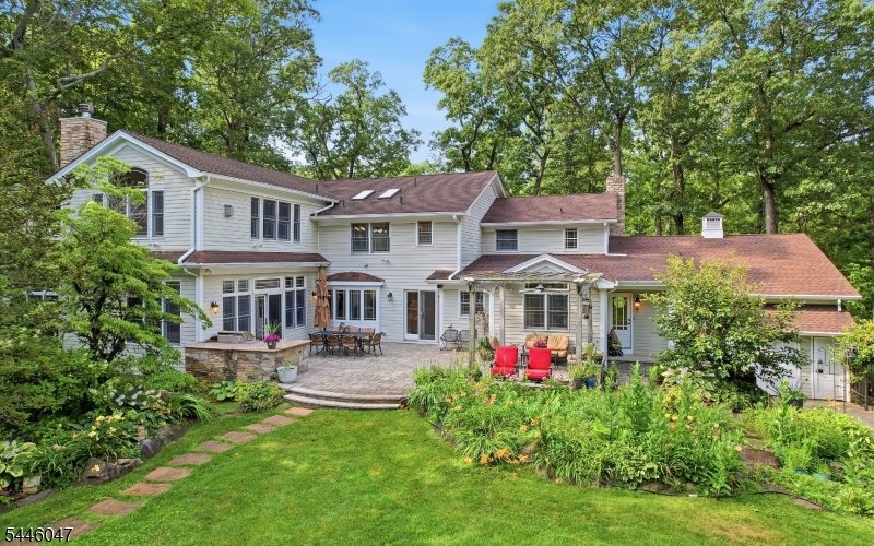 Set on approximately 1.5 private acres in one of Watchung's most desirable neighborhoods, this inviting 4-bedroom residence is designed for comfortable everyday living and effortless entertaining, featuring a chef's kitchen with multiple cooking stations, two dishwashers, and French doors opening to an expansive paver patio with built-in natural gas grill.  The spacious primary suite is a private retreat with an adjoining home office, two walk-in closets, and a spa-inspired bath.  Additional highlights include a first-floor office/flex room, h/w floors throughout, central vacuum, a hardwired security system, a detached garage offering electricity and skylights.  The finished lower level presents a recreation room, bar, wine room, workshop, full bath, and abundant storage.  Step outside to discover a backyard oasis featuring an in-ground pool with cabana, koi pond, and beautifully maintained gardens, mature trees and lush landscaping, creating the perfect setting for entertaining or relaxing in total privacy. Conveniently located just minutes from shopping, dining, parks, and major highways for easy commuting to Newark, Jersey City, and Manhattan. This is a rare opportunity to own a home that combines space, privacy, and exceptional outdoor living.  Schedule your private showing today and experience all this remarkable property has to offer!  New pool filter 7/2026.  The chandeliers in the breakfast room, family room and entry way by the back door to the basement are excluded.