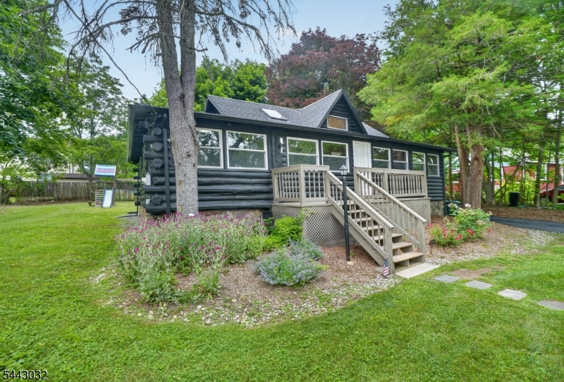 Welcome to 53 Lakeview Drive, a charming log cabin tucked in the sought-after Lindy's Lake community in Lower West Milford! This completely renovated cabin offers 2 bedrooms plus an additional sleeping loft, and fully updated bath. The new kitchen and bath anchor a home that blends fresh finishes with traditional cozy log cabin character. A fireplace sets the scene for warm winter nights, while the huge backyard delivers space for fire-pit gatherings and a hot tub under the stars. Covered parking adds everyday convenience. Enjoy full lake rights and access to the community's sandy beach on Lindy's Lake -- a spring-fed lake known for its crystal-clear water that offers resort-style living, every day.  It's perfect for swimming all summer long, and ice skating and ice fishing once the winter sets in. The home is ideally located: close to Warwick skiing and area attractions, with an easy commute of under an hour to Manhattan. Currently operating as a successful Airbnb investment property with incredible returns. This is a rare turnkey opportunity for buyers looking to continue the income stream or make it their own. Live. Invest. Love.