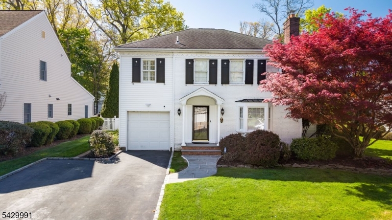 Quintessential Colonial in the sought-after Deerfield section of Short Hills, this updated home offers timeless charm, modern comfort, open-concept flow, and exceptional indoor-outdoor living. A welcoming foyer opens to an elegant formal living room with pocket doors, a bay window, and a gas fireplace that adds warmth and character. Beyond the formal dining room, a tucked-away first-floor office provides a quiet retreat. The heart of the home unfolds across an impressive family room with soaring ceilings, custom built-ins, abundant natural light, and a second gas fireplace. The expansive center-island kitchen is designed for everyday ease and effortless entertaining, featuring high-end stainless steel appliances, generous prep space, a large pantry, and a sunny breakfast area. French doors open to a bluestone patio with built-in benches and a large, level, fully fenced backyard, where perennial bloom throughout the seasons. Inside access to the attached garage and a spacious powder room complete the first level. Upstairs are four generous bedrooms and two full baths, including a serene primary suite with walk-in closet and private bath with jetted tub and separate shower. The finished lower level offers flexible space for recreation, fitness, media, or hobbies. Convenient to Millburn schools, major highways, The Mall at Short Hills, Newark Liberty Airport, Midtown Direct trains to NYC, and all that Short Hills has to offer.