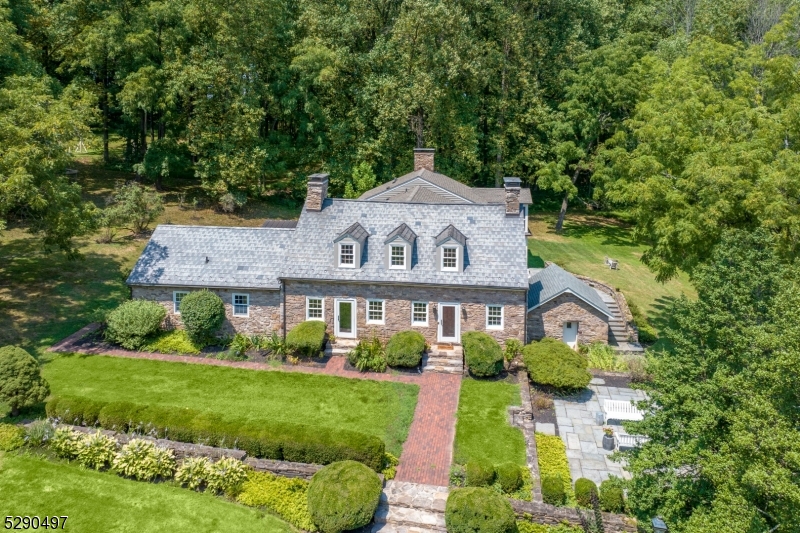 Nestled in the serene countryside of Sergeantsville, NJ, this circa 1737 home boasts four bedrooms and three and one half baths. The timeless charm of the stone exterior and slate roof is complemented by modern updates.  Recent additions include a bright, modern kitchen with high-end appliances and an oversized island, plus a spacious mudroom and laundry room with custom built-ins.  As you enter the home you are greeted with an oversized stone surround fireplace, one of the three wood burning fireplaces.  The sunroom, family room and screened in porch which is attached to the primary bedroom all overlook extensive slate patios surrounded with fieldstone walls and a large pond with dock at a short distance.  A first floor bedroom suite includes full bathroom with a large stall shower.  The property also features a separate guest cottage with two bedrooms and two full baths, a full kitchen complete with island and one car garage.  A detached three-car garage with a game room sits across a circular driveway away from main house.  Extending down a short driveway, there is a new climate controlled barn currently used for car storage. Beyond the barn are extensive open fields.  Spanning over 200 plus acres, this estate offers ample privacy and a picturesque setting, ideal for those seeking a blend of historic charm and modern amenities, hobby farm, multi-generational compound and/or the potential for subdivision. Home is circa 1737 but owners maintain development rights.
