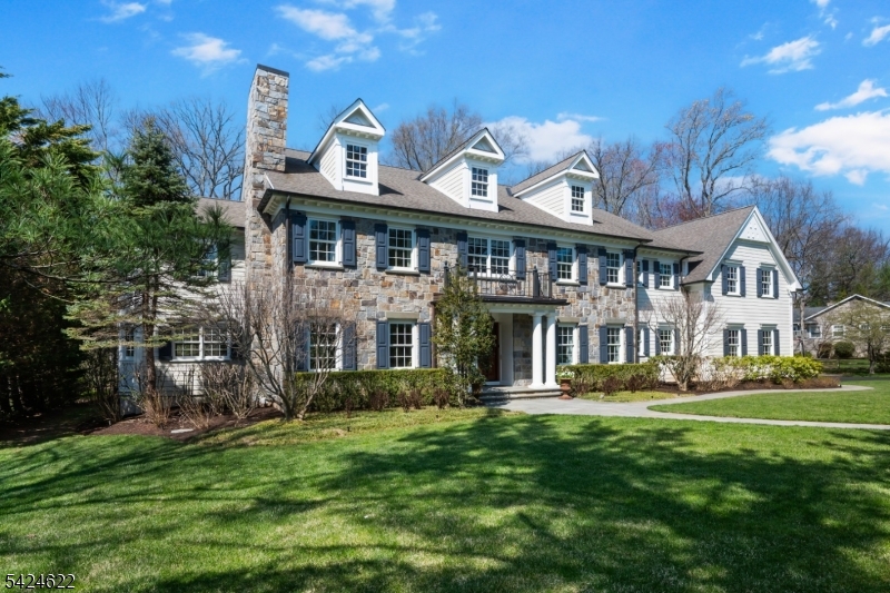 Discover gracious living in this 5/6-bedroom Bucks County colonial, beautifully crafted of stone and clapboard on nearly an acre along Pine Way, one of New Providence's most desirable streets. Thoughtfully designed, the home offers seamless indoor-outdoor living with exceptional workmanship and style. Inside, quartersawn wood floors, fine millwork, and generously scaled rooms highlight the timeless style. The chef's kitchen features a granite-topped center island, abundant cabinetry, and high-end appliances opening to the main living areas. French doors lead to a covered mahogany deck and bluestone patio overlooking lush, landscaped grounds perfect for al fresco entertaining. The expansive primary suite includes a sitting room, spa-like bath, spacious dressing room, and multiple closets. The finished lower level provides a recreation room, media area, gym, and full bath. The natural gas-powered generator supports most major systems, ensuring comfort and convenience year-round. Close to top-rated schools, shopping, dining, NJ Transit, Route 78, and Newark Liberty International Airport.