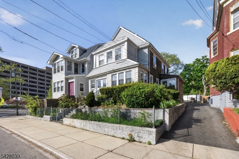 Spacious 7-bedroom, 2.5-bath home situated on a large lot in Newark. You're welcomed by an enclosed porch upon entry, opening into a spacious main living area with a bright, naturally lit sunroom to the right, offering additional usable space. The property features recent renovations on the 1st and 3rd floors, including an expanded 3rd level offering additional living space, creating a flexible and expansive layout. The second level includes an additional room that can be used as a home office or flex space. Additional highlights include fully paid-off solar panels offering additional income and energy savings (historically approx. $3,000 annually), and a large rear parking area. Conveniently located near Newark Beth Israel Medical Center, Weequahic Park, major highways, shopping, and public transportation. A unique opportunity with endless potential schedule your private showing today!