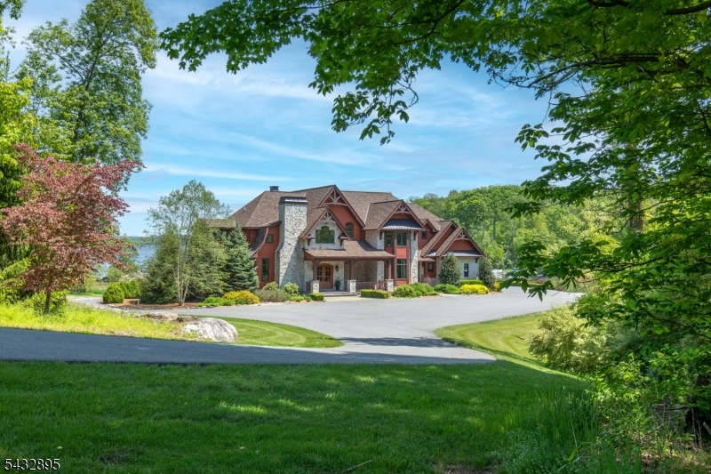 Welcome to 1 Lakeview Point Avenue, an extraordinary custom lakefront estate set on one of Culver Lake's most coveted point lots. Privately gated and beautifully positioned on over 8 acres with more than 300 feet of direct frontage, this 2017-built retreat captures sweeping, unobstructed lake and mountain views from an exceptional setting.The approximately 8,000+ sq ft residence is designed for both everyday comfort and memorable entertaining. Soaring ceilings and walls of glass frame the views, while the open Great Room features a dramatic dual-sided fireplace and flows to a custom bar with backlit onyx accents. The chef's kitchen offers a large center island, top-tier stainless appliances, and a wood-burning fireplace with onyx detailing. A screened lakeside dining porch extends the living space outdoors.The main level includes a serene primary suite with lake views and a spa-like bath, plus an additional en-suite bedroom. Upstairs are four more en-suite bedrooms, including two with private balconies, along with a two-story game room with bar and balcony. The finished lower level offers a theater, wine cellar, gym, sauna, recreation space, two additional bedrooms, and a full bath. A 46' x 22' garage provides generous storage.Outside, enjoy a private beach, 3 docks, boat launch, lakeside firepit, manicured lawns, and full-size tennis, basketball, and bocce courts. A rare Lake estate offering privacy, scale, recreation, and unforgettable four-season lakefront living.