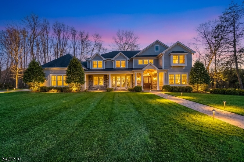 Welcome to 106 Koch Lane, a spectacular luxury residence nestled on a quiet cul-de-sac in the heart of Old Tappan, located within the town's highly sought-after Blue Ribbon school district. This impressive custom-built home spans approximately 5,914 square feet on an expansive 0.87-acre lot, offering exceptional space, privacy, and modern design. A dramatic two-story foyer introduces an elegant layout ideal for today's lifestyle, featuring a first-floor bedroom, private home office, formal living room, and a spacious family room with a gas fireplace. The modern eat-in kitchen features a large center island and sliding glass doors leading to the patio, creating seamless indoor-outdoor living. A custom wet bar with sink connects to the formal dining room, perfect for entertaining. The second level offers four generously sized bedrooms, a second laundry room, and a large recreation space ideal for a gym, media room, or playroom. The primary suite includes his and her walk-in closets and a beautifully appointed bath with double vanity, soaking tub, and separate shower. Thoughtful design and impressive scale create a warm yet refined living experience in one of Bergen County's most desirable communities.
