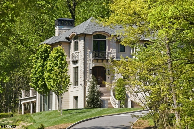An architectural masterpiece by Jeffrey A. Beer A.I.A., this extraordinary estate is a bold statement in design and innovation. Conceived as both a sanctuary and a showcase, it blends state-of-the-art engineering with artisanal craftsmanship to redefine modern luxury living. From the moment you enter the grand foyer, soaring ceilings and walls of glass create an atmosphere of drama and elegance. Every room showcases uncompromising detail, from a chef's kitchen blending function and artistry to expansive spaces for both intimate and grand gatherings. Exceptional amenities set this residence apart, including a 75-foot custom firing lane, elevator to all levels, and an indoor pool and spa for year-round leisure. A cinematic theater, sprawling recreation rooms and dual outdoor kitchens with patios make this an entertainer's dream. Smart home systems manage lighting, climate, security, audio and automated window treatments with precision to ensure comfort and control at every turn. The private quarters are equally impressive. Four upstairs bedrooms each offer en suite baths to provide a perfect blend of luxury and privacy, while the main level primary suite is an oasis of tranquility, meticulously customized with the finest finishes. Every detail, from materials to proportions, reveals the vision of a master architect. More than a home, this residence is a living work of art that embodies bold design and timeless character, unlike anything else on the market.