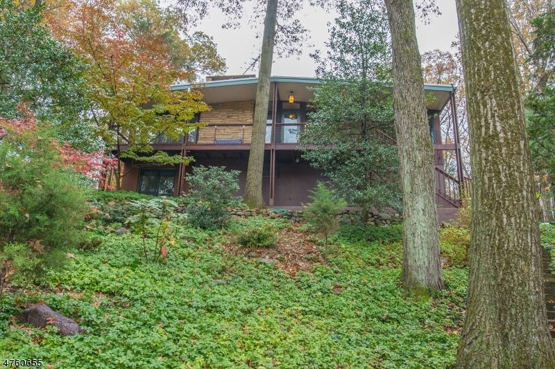One of a Kind Home! Open Floor Plan. 2 Car Garage. Lots of storage. This unique home, is tucked away on private, wooded lot in the heart of Denville. Lots of windows & glass to enjoy nature all year. It features an open living concept with natural wood floors & stone fireplace complimenting the natural setting. Grand kitchen with lots of counter & cabinet space. 3 bedrooms on same floor as living space. Large family room on ground floor! 2 Ceramic full baths & a half bath in basement off double garage! A true haven, every room boasts a view that gives you that sense of nature. You will feel miles away from the hustle & bustle even though you are just minutes away from NYC Direct trains, bus and major highways. Take advantage of desirable downtown shopping, restaurants, parks, community events. Top Schools!