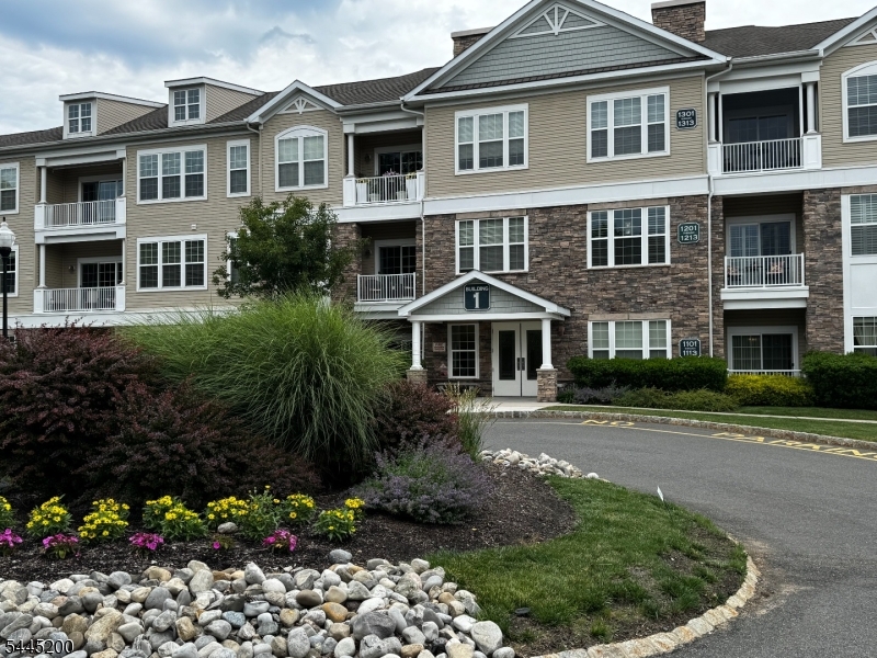 Welcome Home to this spacious Ramapo Model approx. 1680 sqft. Located on the 3rd floor with no residence above. Step inside to the high ceilings and open floor plan of the LR/DR providing a bright and airy atmosphere. Den located adjacent to LR with windows. The private open porch is accessed via sliding doors overlooking a tree lined area where you can start your day or settle in and unwind in the evening, The Kitchen has granite counters with a breakfast bar view to the LR/DR; great for entertaining! There are High cabinets 42", pantry and SS Appliances. Spacious Primary bedroom with large walk-in closets, and wall with windows to let the sunlight in. Second Bedroom is also spacious with private on-suite as well. Powder Room near main living spaces. Hardwood Floors in LR/DR/Den/Foyer. Large spacious Laundry Room with closet. There is an underground garage parking spot with storage right in front and conveniently located right near elevator leading up to this unit!  The Greenbriar at Fox Ridge is tucked away with a beautifully landscaped community just minutes from major highways, public transportation, shopping and entertainment. The community itself provides many amenities - indoor and outdoor pool, gym, Billiard room, tennis courts, large community center. Come see for yourself; this could be the home you've been looking for!