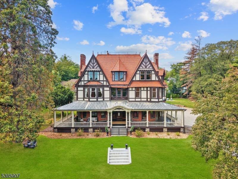 Offered for only the second time in nearly 130 years, this extraordinary estate presents a once-in-a-generation opportunity to own one of Montclair's most distinguished properties. Set on nearly two private acres atop a rolling hill, the residence seamlessly blends historic grandeur with modern luxury while capturing breathtaking New York City skyline views. A gracious wraparound porch welcomes you into sun-filled interiors showcasing exquisite original millwork, oversized windows, and timeless architectural details. Extensive updates, including a renovated chef's kitchen, updated electrical, plumbing, and HVAC systems, provide modern comfort while preserving the home's character. Designed for elegant entertaining and everyday living, the home offers 9 bedrooms, 5.1 baths, and 2 versatile bonus rooms. Professionally landscaped grounds feature expansive paver patios, a fenced yard, and tranquil green spaces. The beautifully updated 3-bedroom, 1-bath carriage house includes horse stables, a full first-floor garage, and its own private driveway, offering exceptional flexibility with potential to expand for additional living space. A rooftop observatory with the original 1986 telescope offers sweeping panoramic views. Ideally located moments from vibrant downtown Montclair, acclaimed dining, boutiques, theaters, museums, and NYC transportation, this remarkable estate offers an unmatched blend of history, luxury, and opportunity.
