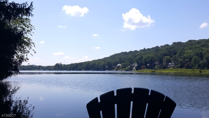 Lakefront Extremely rare to find in this price range - on beautiful Cedar Lake with approx. 100 ft of lakefront with dock, expansive westerly views.  This is the quiet and more private north end of this 99 acre lake.  Hiking abounds with Jonathan Woods, etc., just down the road.  Remodeled since 2019, includes newer kitchen, remodeled great room incorporates old sunroom, heating/ac, sytem, roof, 26 hi hats, retaining wall along driveway facing lake.  Includes dramatic stone heatolator fpl, volume ceiling, DR, 3 BRs - one with walk-in closet, (which in a possible remodel could become master bath with lakeviews!).  Separate access at ground level to 2 car garage and utility/storage room. Stack style washer/dryer is presently in one of the BR closets could be moved to hall closet; there is also hookup not currently in use in util. rm.. This is a neighborhood of milion dollar + homes.   Paved area in front of house separates the house from the lake access but is the owners property nonetheless.  There is one other house beyond this one which has access over this paved way. Easy in town access to NYC direct rail and bus.  Take advantage of this affordably priced home to access a fantastic combination of lifestyle offerings - being on a lake and part of a lake community, in an award winning town. Mandatory Lake Dues $600 in 2026. Non-motorized boats only. Optional Cedar Lake Community Club dues $140 approx. gives you access to club activities.  Being SOLD IN AS-IS CONDITION