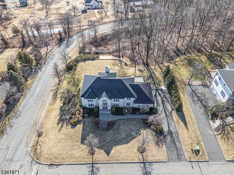 Situated on a peaceful cul-de-sac in one of Denville's most sought-after neighborhoods, this expansive custom home offers an upscale lifestyle & nearly 5,000 sqft of living space.  Architectural details abound, including high ceilings, HW flooring, decorative moldings, & accent lighting. The grand 2-story foyer is flanked by a formal dining room & a large formal living room & a dramatic double curved staircase adds to the home's elegance.The heart of the home is the FR, which boasts cathedral ceilings & a gas fireplace, creating an inviting space for entertaining which seamlessly flows into the eat-in kitchen, with granite countertops, a Chef-grade Viking 6-burner gas oven, SS appliances, & a center island. Large windows bathe the home in natural light. The 1st floor also includes a study or optional bdrm w/a full bath close by. Upstairs, there are 4 more bdrms, 2 of which have private en-suites & walk-in closets. The luxurious primary boasts 2 walk-in closets & a spa-like bath w/2 vanities, jetted tub, stall shower, and 2 linen closets. The full, unfinished bsmt w/high ceilings presents endless possibilities for addtl living space. The laundry seamlessly transitions you in from the 3-car garage w/electric car chargers. If this home isn't impressive enough, the Solar Roof shingles & power will steal the show! Powers the home 24/7 & through all outages. The glass solar tiles & steel roofing tiles look great up close & from the street, complementing the home's classic style.