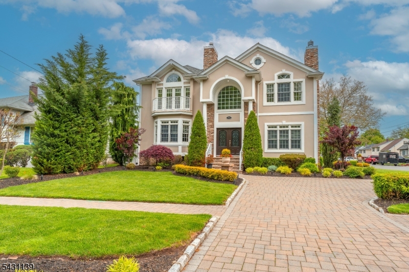 This newly renovated Colonial home filled with character commands attention on a corner lot where meticulously manicured landscaping and a sweeping paver driveway create undeniable curb appeal. As you enter through ornate double doors, a breathtaking two-story foyer welcomes you with soaring ceilings, gleaming hardwood floors, and an abundance of natural light throughout. Custom molding and architectural details add sophistication at every turn. The expansive living room features a gas fireplace flanked by arched windows, while the formal dining room is crowned with a designer chandelier and framed by a bay window. The showstopping chef's kitchen boasts bright cabinetry, crisp countertops, a generous center island with breakfast bar, and crystal chandeliers overhead. A first-floor bedroom and full bathroom with walk-in rain shower offer flexible living and added convenience. Upstairs, the luxurious primary suite features a vaulted ceiling, stone accent wall, gas fireplace, private balcony, and spa-worthy en-suite with soaking tub. A princess suite with vaulted ceiling and en-suite bath, two additional spacious bedrooms, a common bath, and a dedicated laundry room with custom cabinetry complete the second level. A two-car garage with epoxy flooring and a fully fenced backyard with paver patio round out this exceptional property, located steps from local bus stops and Lenape and Nomahegan Parks.