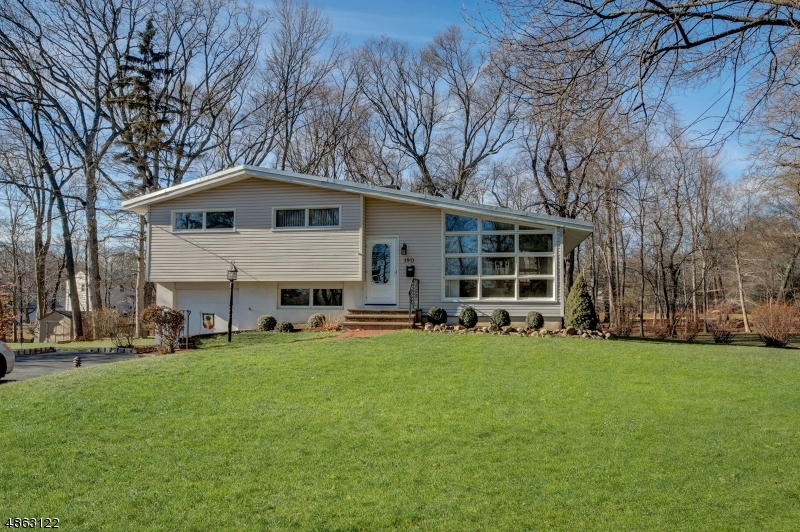 Gorgeous split level on .48 private acres w/ an arborous backyard, beautifully landscaped & located on a quiet cul-de-sac min from transportation, schools, parks, Lake Parsippany & shopping. Welcome guests into the sunlit living rm w/large windows & beamed ceiling, or entertain in the dining rm w/sliding doors to the deck. A stunning kitchen feat. abundant cabinets, custom tile & granite countertops that will delight even the most demanding homeowner. Relax on the deck overlooking the wooded yard. The master bedrm includes plush carpet & large closet, two additional bedrms w/hardwd floors provides plenty of space for guests, & hallway bath w/custom tile & bathtub/shower combo. The ground level feat. family rm w/built-in bookcases & additional closet space, bedroom, mud rm & half bath.