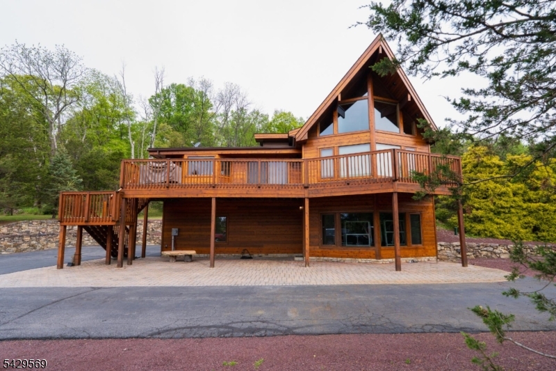 Magnificent custom-built Lindal cedar home featuring premium Canadian-sourced planking and beams, privately set back on an elevated homesite with breathtaking mountain views. Accessed by a 700-foot paved driveway, this exceptional property showcases quality craftsmanship and thoughtful design throughout. Great Room offers 24-foot ceilings, post-and-beam wall of windows, handpicked fieldstone wood-burning fireplace, hickory hardwood flooring, and built-in surround sound. An open floor plan flows to a spacious TimberTech deck with a propane-connected grill, perfect for entertaining. Front entry with biscuit-joined front door and mahogany flooring. Kitchen with cherry cabinetry, granite countertops, double ovens, stainless steel appliances, and a nearby laundry room. Upper-level primary suite with mountain views, private deck access, walk-in closet, and a luxurious marble bathroom with Kohler dual showerheads. Two additional bedrooms on main level, with potential for a fourth bedroom in the finished walkout basement. Lower Level with radiant heated floors, additional living space, and a workout area. Additional features include central vacuum, five-zone heating and cooling, Peerless furnace with Beckett burner, two hot water heaters, Generac generator, and owned 500-gallon propane tank. The three-car garage with radiant heat and air conditioning. A town-certified 4-bedroom septic system allows room for future expansion and a brand-new roof being installed for added peace of mind