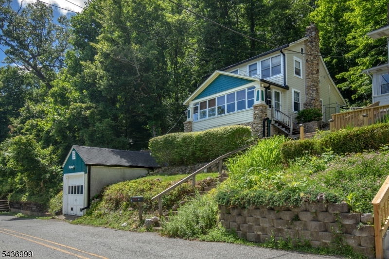This is a unique offering: 4 separate lots being offered together. Combined, the parcel offers 132 ft of waterfront and .69 acres. The charming lakeside getaway with incredible water views, seamlessly blends classic cottage character with comfortable living. Enter the home onto an enclosed porch and appreciate all the seasonal views. Inside, there are wood floors throughout and the tongue-and-groove woodwork adds architectural detail. A  woodstove provides warmth during cooler days.  Rich craftsmanship defines the interior spaces, where the natural wood accents create a welcoming atmosphere. The thoughtful layout maximizes the stunning scenery, ensuring the water remains a constant backdrop. The cottage has a 2 bedroom septic with flex space that the current owners use as a guest room. 2 private dock areas, with stairs leading to each, provide direct access to the lake and plenty of room to entertain, waterside. Complete with a detached one-car garage, this property is situated near Route 80, offering a fantastic balance of peaceful waterfront relaxation and easy commuting convenience. Everyday life feels like a retreat with opportunities for kayaking, canoeing, swimming, and ice fishing right from your own yard and Jenny Jump State Park is just down the road. The pristine lake accommodates electric motors only. 2022 new roof, gutters and gutter guards. Enjoy the peaceful, serene lifestyle of living on the lake!