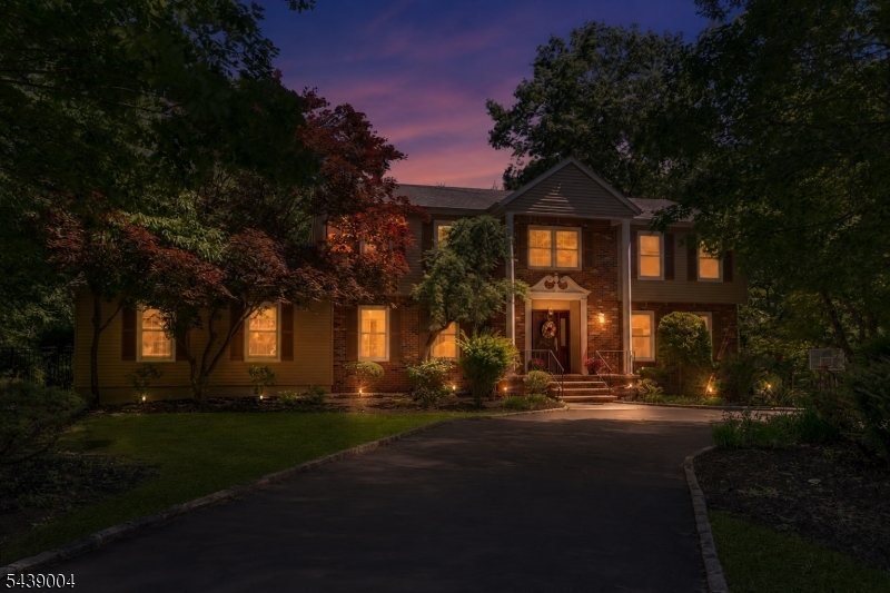 Welcome to 10 Moonshadow Ct, a distinguished Colonial tucked at the end of a private cul-de-sac just off coveted Denise Drive, one of Kinnelon's most desirable residential locations. Surrounded by mature trees and a peaceful wooded backdrop, this expansive home offers privacy, flexibility, and timeless appeal. A dramatic two-story foyer welcomes you into a thoughtfully designed floor plan featuring generously sized living and entertaining spaces. The heart of the home is the expansive great room, flowing seamlessly into the kitchen, dining area, and sun-filled solarium, creating an inviting setting for everyday living and entertaining. The main level includes a bedroom, full bath, and laundry room, providing exceptional flexibility for guests and a convenient first-floor living option. Upstairs, the spacious primary suite serves as a private retreat and is complemented by two additional bedrooms and a dedicated office, ideal for today's work-from-home lifestyle. The finished lower level offers versatile space for recreation, fitness, media, hobbies, or play. Outside, an expansive deck overlooks the private backyard and wooded surroundings, creating a peaceful setting for outdoor dining and entertaining. An in-ground pool offers the opportunity to create your own outdoor retreat. Combining timeless Colonial architecture, exceptional living space, and a sought-after location, 10 Moonshadow Ct offers the comfort, privacy, and flexibility to enjoy for years to come.