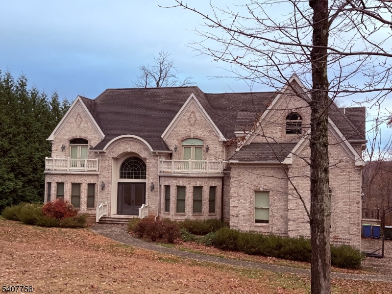 Welcome to this exceptional custom-built brick Colonial, where timeless architecture meets refined craftsmanship.  A grand double-door entry sets the tone, opening into a stunning sun-filled marble foyer that immediately showcases the home's elegance and scale.  Rich hardwood floors flow seamlessly throughout, complemented by exquisite custom millwork and detailed finishes that elevate every space.  The inviting family room fireplace serves as a stunning focal point-perfect for cozy evenings and relaxed gatherings. At the heart of the home is a beautifully designed, spacious eat-in kitchen-perfect for both everyday living and entertaining.  Featuring a large center island, convenient breakfast bar, and abundant counter space, this kitchen offers both function and flow.  A dedicated pantry provides excellent storage, while the generous layout allows for a comfortable dining area filled with natural light. Designed for both comfort and versatility, the main level features a desirable first floor bedroom with a full bath, ideal as an in-law suite or for guests.  Upstairs, you'll find four generously sized bedrooms, including a luxurious primary suite retreat.  The primary bedroom offers its own private sitting room with a double-sided fireplace - perfect for unwinding at the end of the day, along with spacious walk-in closets.  A true blend of classic Colonial charm and modern livability, this home delivers elegance, warmth, and thoughtful design in every detail.