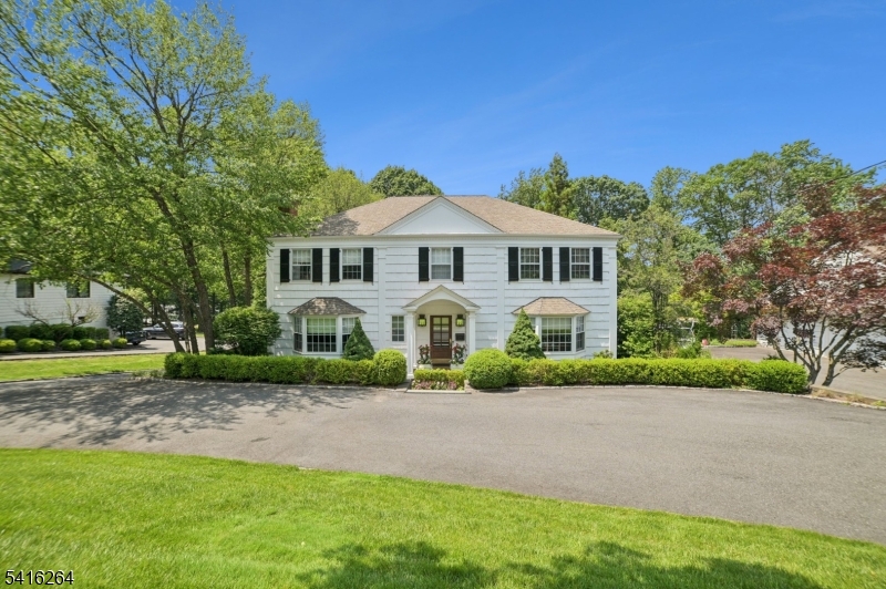 Nestled in one of Short Hills' most sought-after neighborhoods, 77 Falmouth Street offers a rare opportunity to own a classic Center Hall Colonial set on .71 acres of beautifully landscaped property just moments from Hartshorn Elementary School. Built in 1965 and thoughtfully updated, this elegant three-level home features 4 bedrooms and 4.1 bathrooms, combining timeless charm with modern comfort. The inviting interior showcases hardwood floors, recessed lighting, stone tile finishes, and custom built-ins. Both wood-burning and gas fireplaces enhance the main living spaces, while central air and a security system add everyday convenience. The renovated eat-in kitchen features marble countertops, stainless steel appliances, a center island with breakfast bar, and a bright breakfast area that flows seamlessly into the family room. Upstairs, the spacious primary suite offers dual closets and a beautifully appointed bath. The finished lower level provides flexible space for recreation, work, or guests. An elevated deck overlooks the expansive backyard and lush landscaping. A true highlight is the golfer's paradise, featuring a professionally designed, fully lit putting green and 50-yard target green perfect for practicing any time of day. Home features a whole house generator.  Fireplace and flue is being sold in AS-IS condition - no known defects