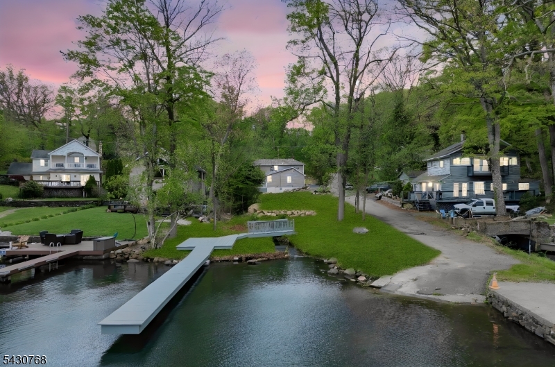 Discover the ultimate lakefront lifestyle on the beautiful shores of Lake Hopatcong, New Jersey's largest lake. Waking up to shimmering lake views from your private balcony, entertaining around a showstopping kitchen island, and ending the day by the glow of a sleek modern electric fireplace, this is what life looks like. Every detail has been refreshed brand-new kitchen with a beautiful center island, all-new light fixtures, fresh paint throughout, new roof, new furnace and central AC, and a brand-new 3-bedroom septic system. There is truly nothing left to do but enjoy. Spend summer days launching from your own private dock, unwind on the deck off the living room sliders, or cozy up to the wood-burning stove on chilly evenings. The primary suite is a true sanctuary with a private balcony overlooking the lake and a gorgeous custom-tiled en suite shower. A first-floor bedroom with its own private bath is ideal for guests. And a massive detached garage handles every hobby, toy, and adventure. The property even features its own private stream, adding a rare and magical touch to an already extraordinary setting. With plenty of off-street parking and a location on one of New Jersey's largest lakes, this is a rare opportunity to own a move-in ready lakefront gem. Schedule your showing before it's gone.