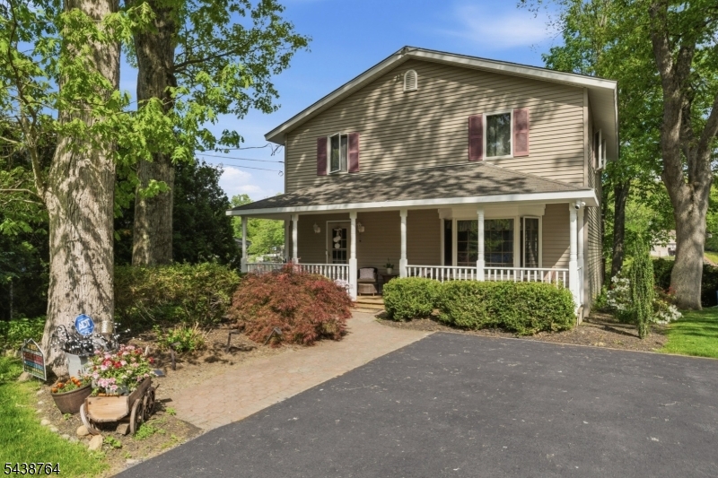 6/1..MAJOR PRICE REDUCTION BY $64,000!Experience lakefront living in this beautifully maintained 4 bedroom, 1.5 bath home in desirable Lake Shawnee. Enjoy stunning water views, hardwood floors, rich wood trim and a bright living room with a grand fireplace and two sliding doors leading to brand new decks overlooking the lake. The updated kitchen features very recent stainless steel appliances, while the finished basement offers additional living space and a workshop.  On the second floor you will find a large Primary bedroom with sliders to a balcony offering serene lake views. Primary has 2 closets, one being a walk in. The other 3 bedrooms are generously sized and all have double closets and lots of light. A freshly painted front porch, new driveway, excellent storage and manicured landscaping make this move-in-ready home truly special. This home has a generator hookup and the lakeside has a dock and  gorgeous views. Basement rooms have electric heat, oil heat for levels 1 & 2.