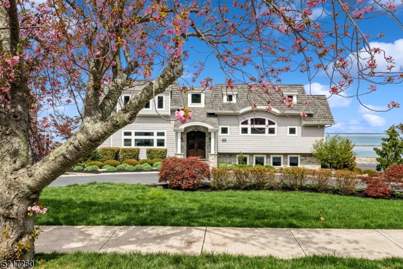 This magnificent, custom built, 7-bedroom 6.5 bath, waterfront dream home, is not only the epitome of comfort & luxury, but also a fortress! As part of the original design, 2 bedrooms & 2 bathrooms were tucked away into an attached guest apartment. Nestled on a prestigious hillside overlooking NYC and situated a few blocks from downtown Atlantic Highlands and the ferry make this an ideal property for anyone looking to reside just a boat ride away from NYC. Beautiful and unpretentious when viewed from the street yet offering a unique blend of elegance, sophistication, and modern convenience once inside. The gourmet kitchen was extremely well thought out & custom designed by an actual chef! Features include top-of-the-line 48" BlueStar Platinum professional range & hood, 42" Sub-Zero Classic French Door Refrigerator/freezer, floor to ceiling intelligently designed cabinets all masterfully encased in custom walnut & centered around a large island. The beautiful quartz countertop, tiled back-splash, and large-rectangle tiled flooring were carefully selected to provide both function & beauty, making this kitchen a true work of art. Conveniently located just off the kitchen is a butler's pantry complete w/ 3rd sink, 2nd dishwasher, add'l floor to ceiling, white, custom cabinets, & exterior door. Not only is this a property you cannot wait to come home to, but an oasis where one comes home to relax, reset, and rejuvenate.