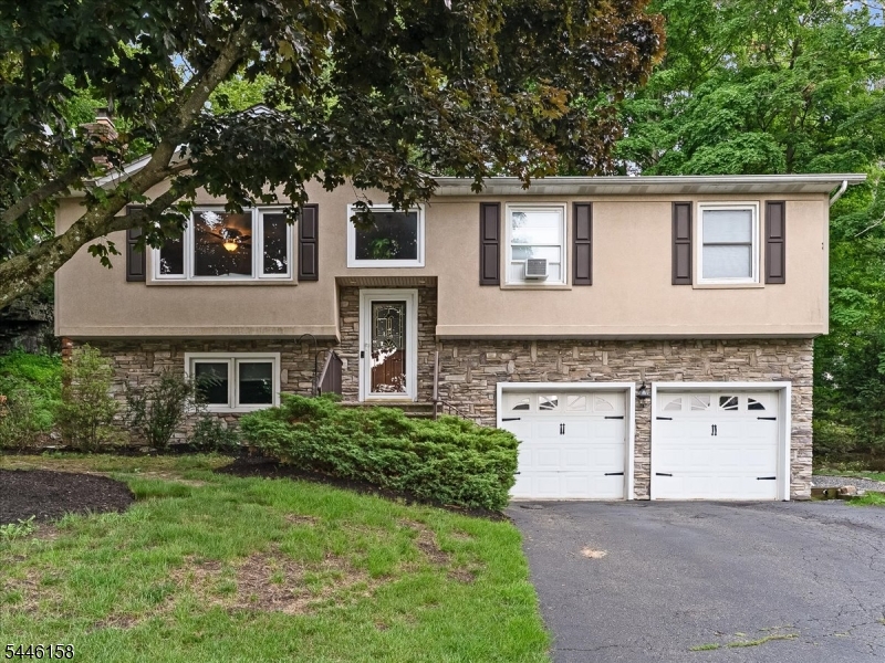 Discover the perfect blend of comfort, privacy and lifestyle in this beautifully maintained four bedroom, two bath bi-level in the desirable Alpine section of Lake Mohawk. Set on a private, level, approx 1/2 acre CORNER lot, this home features hardwood floors, white washed fireplace, a sun filled primary suite with a skylight and a finished lower level offering versatile living space ideal for a family room, recreation area, home office or guest accommodations. Experience endless hot water with a tankless hot water heater. Designed for effortless indoor/outdoor living, the expansive two-tier deck leads to a dedicated hot tub platform with hookups already in place, while the detached garage provides additional storage. Enjoy coveted Lake Mohawk lake rights, offering access to private beaches, boating, fishing, swimming and year round recreation. An exceptional opportunity to delight in  the lake Mohawk lifestyle in a peaceful sought after setting.Buyer to verify all Lake Mohawk dues. Fireplace as is.