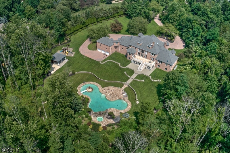 Offered at $200,000 below Township's assessed FMV, With an estimated replacement value exceeding $11M, this remarkable estate stands as a testament to exceptional craftsmanship, scale and irreplaceable amenities. Truly spectacular custom built all brick manor estate set on twelve lush and private acres, this exceptional residence showcases uncompromising craftmanship, timeless architecture and one of the most remarkable outdoor entertainment environments in the region. Resort inspired aquatic masterpiece featuring a grand pool, elevated spa terrace, grotto with integrated seating, three dramatic waterfalls, private island and expansive pavilion w/ full bar and gathering area. The home captures panoramic vistas from nearly every room through towering windows and French doors.  Ensuite bedrooms, dual level master suite and guest areas with quiet nooks and open entertainment areas throughout the home, there is tranquility or action as desired by the owners and their guests.