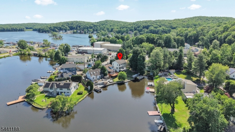 Rare lakefront Colonial on Brights Cove, Lake Hopatcong. Quality built in 2005 and move-in ready. Level lot with dock, bulkhead & easy access to the main lake. The open floor plan is bathed in natural light with panoramic cove views from the entire back of the home through double sliders and oversized windows. Dream kitchen features maple cabinetry, granite countertops & center island. Gleaming hardwood floors, ceramic tile & carpeting throughout. 2 bedrooms plus a den & 2.5 baths   Primary en suite boasts private bath & second-tier balcony overlooking the lake & mountains. Convenient laundry in the second floor hall bath. Recessed lighting, central A/C, hot water baseboard heat, city water, septic. The full walk-out basement is an entertainer's dream,  featuring a built-in bar, generous open space for gatherings, a private entrance for guests, and a full interior stairway. High ceilings, no columns, and a huge floored attic round out this exceptional home. Fully fenced yard. Deck overlooking the cove- perfect for entertaining. Already have a boat or dreaming of owning one someday? Your private dock & bulkhead are ready and waiting - cruise to lakeside restaurants, shops & marinas right from your backyard. Minutes to Rt. 15, major highways & Mt. Arlington Train Station. This is lake life at its finest - don't miss it!