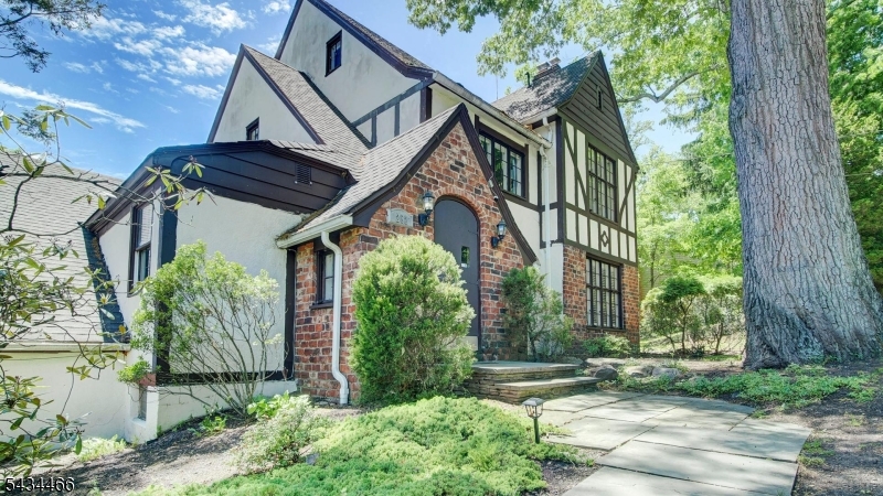Classic architectural character meets excellent functional design in this spacious 4 bedroom Tudor home. The stately brick and timber facade welcomes you with a striking arched entry door and timeless windows that flood the interior with brilliant natural light. Inside, the expansive living room features pristine hardwood flooring and a cozy fireplace, flowing effortlessly into a formal dining room that offers plenty of space for entertaining. The heart of the home features a kitchen equipped with rich wood cabinetry, a classic tiled backsplash, and stainless steel appliances. This space transitions into a dramatic breakfast area boasting a vaulted ceiling and panoramic windows. For those who work from home, the property includes a generous office with custom built-in shelving, alongside a massive seasonal screened in porch that offers a versatile environment to enjoy the fresh air.The outdoor spaces serve as a beautiful personal resort. A comfortable patio area sits just off the house, while a walkway leads to an elevated deck and a refreshing above-ground pool. Surrounded by mature trees and pristine landscaping, this backyard creates a private, self contained retreat. Whether exercising by the pool, working from the sunlit office, or hosting dinner parties, this property offers an exceptional layout that makes it feel like a world away from everything.