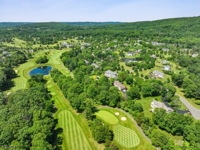 Experience luxury living in the prestigious Stanton Ridge Golf & Country Club community, where breathtaking mountain views create a stunning backdrop for this exceptional home set on 2 private acres, in a quiet cul-de-sac and overlooking the 17th hole. Designed for both everyday comfort and grand entertaining, this home offers a spacious floor plan filled with quality craftsmanship and extensive custom details throughout. The remodeled gourmet kitchen has a large center island, custom cabinetry, high-end appliances, striking Versace backsplash, and under-cabinet lighting. Entertain effortlessly in the elegant den with wet bar and fireplace. First-floor in-law suite. Sophisticated finishes include hardwood flooring, coffered and tray ceilings, Venetian plaster walls, custom built-ins, and designer closet. The luxurious primary suite offers tray ceilings, spa-like bath with Jacuzzi tub, and an expansive dressing room. Additional bedrooms are exceptionally spacious, while the second floor also features a large recreation room. The finished walkout lower level includes a bar, rec area, media room, full bath, and abundant storage. Outside, enjoy a huge patio and sprawling backyard perfect for entertaining or relaxation. Stanton Ridge offers optional golf and social memberships w/ golf, pool, clubhouse, restaurant, bar & tennis/pickleball. Conveniently located near NYC train service, restaurants, shopping, highways, and Round Valley Reservoir for hiking, biking, boating, & fishing.