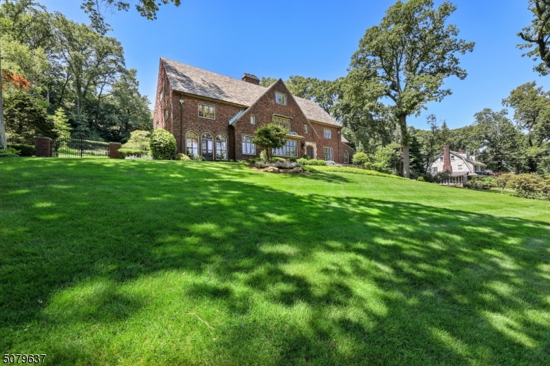 Stately, elegant, warm & welcoming, this brick Tudor was beautifully built & meticulously maintained. NYC views. Incredible architectural details, wide plank floors, stained glass windows plus  FP with limestone mantle. Fabulous for entertaining. Gracious foyer leads to formal rooms/special details including Batchelder tile fountain & floors in sunroom & sitting rm adjacent to DR. Library/gas FP. Updated eat-in-kitchen/high end appliances & butler's pantry.  Lavish primary BR suite/renovated bath/radiant heat.  Billiards rm & media rm on 3rd flr.  Fun family rm in lower level plus gym & tons of storage.  C/A on 2nd, 3rd floors plus kitchen & sunroom.  Perfectly set on almost an acre & a half of private, professionally landscaped property/fully fenced backyard.  This is a jewel not to be missed!