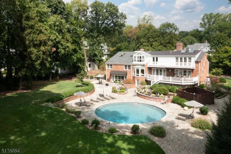 Private living in a prime Northside location on .84 acre's. This custom 5 bed, 4.2 bath home is bright, airy and has great flow. This home combines the open entertaining space with the versatility of separation and stand alone rooms for work, fitness and relaxation. With 3 levels that are above ground you have tremendous views out to the private backyard oasis that has a large mahogany deck, blue stone patio, pool and lush gardens and lawn. When entering the home you are greeted by the living room which has a see through gas fireplace that opens to the formal dining room. The designer kitchen with two islands, high end appliances and breakfast area opens to a family room. Upstairs there are 3 bedrooms, one of which is en suite and the other two share an updated hall bath. The floor above has a bedroom with ensuite, a yoga/meditation room or office and the master suite that has large walk-in closets, a shower and soaking tub that has a peaked glass ceiling, perfect for relaxing inside and looking up into a star filled sky. The expansive garden level features a walk-out family room with fireplace and summer kitchen including countertop sink, microwave and dishwasher that opens to the pool areas-this acts as a pool house. Large media/game room, home gym, craft room and laundry room, plus access from the oversized heated 2 car attached garage adds convenience.