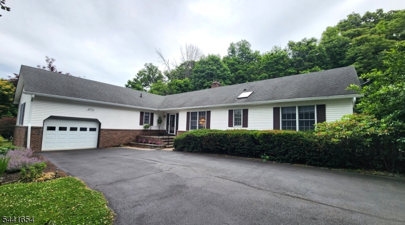 Welcome home to well maintained 4-BR, 2.5-bath ranch set on picturesque private 2-acres. Tree-lined drive creates welcoming approach leading to attached 2-car garage w/  openers & peaceful setting surrounded by nature. Hdwd floors throughout complemented by spacious formal LR & DR ideal for everyday living & entertaining. Completely renovated kitchen feat granite, SS appliances & abundant cabinetry. Adj to kitchen, light-filled breakfast rm boasts skylight & multiple windows to showcase serene backyard. Inviting den offers brick wood-burning FP w/ insert creating warm & cozy gathering space. French doors open to stunning tiled 3-season sunroom w/ vaulted ceilings & walls of windows, bringing outdoors in. Step outside to deck overlooking private backyard, perfect for relaxing or entertaining. Paver walkway wraps around home & connects seamlessly to driveway. 4 generously sized BR conveniently located down hall, incl primary suite feat walk-in closet & updated bath w/ beautifully tiled shower & glass enclosure. Vanity area is thoughtfully positioned outside bath for added convenience. Full hall bath w/ skylight, tub/shower combo & linen closet. Add'l feat incl 1st-floor laundry, powder room, central air, generator hookup, storage shed & full unfinished basement w/ dedicated train room & endless potential for future expansion, recreation or storage. Offering ease of 1-level living, thoughtful updates & exceptional indoor & outdoor spaces property is perfect place to call home.
