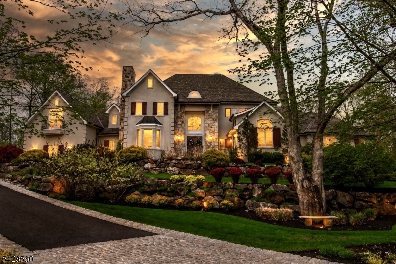 Welcome to Bear Rock Estates, where luxury, lifestyle, and location converge on 2.75 acres of lush, professionally landscaped grounds; an exceptional private retreat designed for elevated living and effortless entertaining. A grand two story foyer sets the tone, leading to a custom chef's kitchen with high end appliances, an expansive center island, a cozy breakfast nook, and a walk-in pantry. The kitchen flows seamlessly into the great room, anchored by a stunning double sided gas stone fireplace, and complemented by formal living and dining rooms, plus a private office. The first floor primary suite is a sanctuary, featuring a sitting area, spa like en suite bath, and a generous walk-in closet. Upstairs offers four beds three w walk-in closets two full baths, and a spacious finished playroom. The lower level is an entertainer's dream, complete with a custom wine cellar, wet bar, open concept home theater, private gym, full bath, and game room with walkout access to your own private oasis. Outdoors, indulge in a resort style backyard with multi level entertaining spaces, highlighted by a one of a kind infinity edge pool overlooking serene wooded views, an outdoor kitchen with a brick pizza oven, and a hot tub. Additionally, 3 car garage plus lift, radiant heated floors on the first level, Sonos audio throughout, and a new roof (2025). Ideally located near parks, hiking trails, top rated schools, fine dining, and convenient access to NYC via bus and Towaco Train Station.