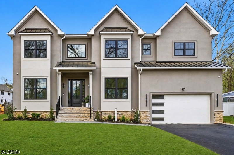 Stunning NEW CONSTRUCTION Center Hall Colonial in one of Scotch Plains' most sought-after neighborhoods. This stucco-front home offers over 6,100 sq ft on a flat 0.36-acre lot with 6 bedrooms and 6.5 baths across three finished levels. A covered porch opens to a dramatic two-story foyer, flanked by formal living and dining rooms. The open layout with 10-ft ceilings is anchored by a breathtaking family room with vaulted ceilings, built-in speakers, and a striking 20-ft tiled fireplace. The space flows into a gourmet kitchen with a quartz center island, walk-in pantry, butler's pantry, and breakfast area. Sliding doors lead to a patio and expansive backyard ideal for a future pool. The main level also features a guest suite with full bath, home office, and mudroom. Upstairs, the primary suite offers a sitting area, dual walk-in closets, and a spa-like bath. All additional bedrooms are en-suite with tray ceilings, plus second-floor laundry. The finished lower level with 9-ft ceilings includes a recreation room, media room, playroom, bedroom, and full bath. Additional highlights include a 2-car garage, EV charger, and 10-year warranty. Convenient to parks, top-rated schools, shopping, dining, and NJ Transit.