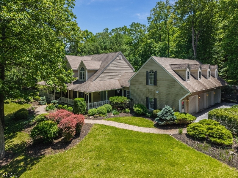 Nestled on five picturesque acres in the heart of Andover Township, this custom-built Colonial offers the perfect blend of timeless elegance, privacy, and modern comfort. Featuring 4 spacious bedrooms, 4.5 baths, and over 12 beautifully appointed rooms, this exceptional residence is designed for both everyday living and grand-scale entertaining. The dramatic two-story great room showcases a stunning floor-to-ceiling stone fireplace and abundant natural light, while the expansive chef's kitchen boasts extensive cabinetry, dual ovens, and ample space for entertaining. The sought-after first-floor primary suite offers a luxurious retreat complete with a spa-inspired bath and dual walk-in closets. Additional highlights include formal living and dining rooms, a finished lower level, and an impressive 4-car garage with bonus space above. Outside, manicured grounds, mature landscaping, and peaceful wooded surroundings create a true country estate atmosphere just minutes from shopping, dining, recreation, and major commuter routes. Experience the rare combination of privacy, space, and sophistication in one of Sussex County's most desirable settings.  It's not just a Home but a Lifestyle!