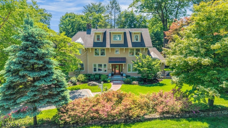 Defined by legacy, craftsmanship, and quiet confidence, this Hapgood Colonial has been deliberately transformed to honor its authentic character while embracing modern refinement; thoughtfully designed for effortless entertaining, everyday comfort, and fluid indoor-outdoor living. The 13-foot coffered family room sets the tone for the home-  grand in scale, intimate in detail. Family room extends to deck through double doors offering seamless indoor/outdoor flow. Beyond the chef's kitchen, appointed with dual sinks and dishwashers, a backyard sanctuary unfolds: a waterfall koi pond, al fresco dining, and a private cottage escape with endless potential. Imagine, a golf simulator, yoga studio, or art room   a haven ready to suit your lifestyle. Additional highlights include: a primary suite with spa-like bath connecting to walk-in closet, in-law suite with private entrance, restored hardwood floors throughout, built in oversized 2-car garage conveniently leading into large mud room, and finished basement with bonus room. This 6 bedroom, 4.5 bath home is nestled in the heart of picturesque Mountain Lakes. Within walking distance to the main lake, top-ranked schools, local dining, park, train, and library.